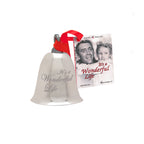 Decorative bell with 'It's a Wonderful Life' text and a small card featuring a classic movie scene on a white background.