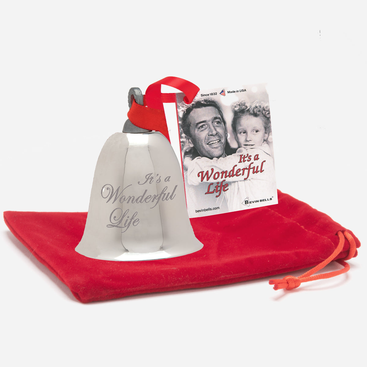 Bell with 'It's a Wonderful Life' text on a red cloth with a movie poster in the background